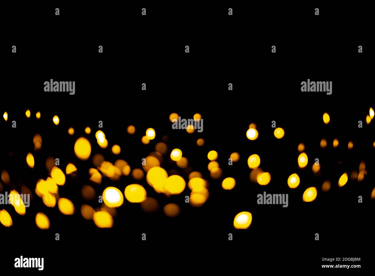 Bright orange specks of light garland shining in dark room during