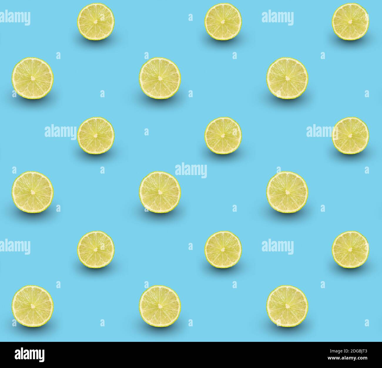 Repeated seamless pattern of many sliced ripe limes on light blue background. Stock Photo