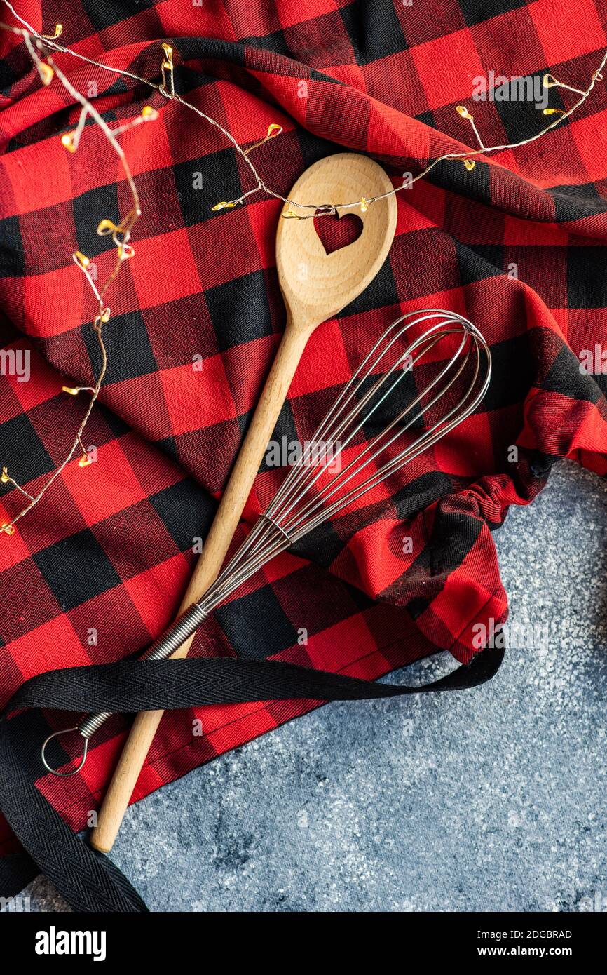 Whisk and wooden spoon on an apron Stock Photo Alamy