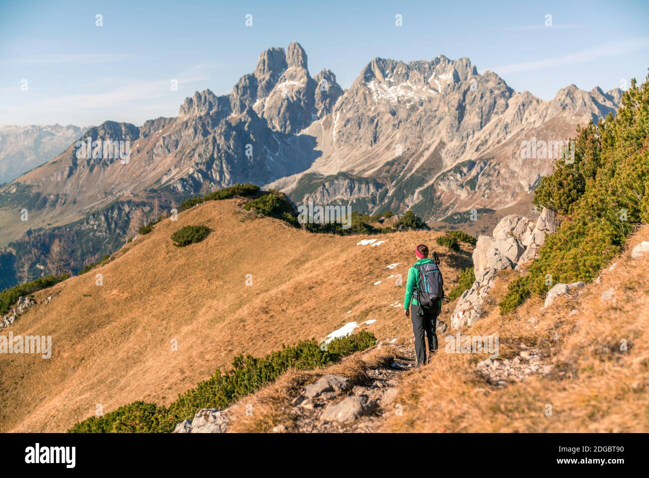 Woman hiking on footpath in alpine landscape in autumn, Filzmoos, Salzburg, Austria Stock Photo