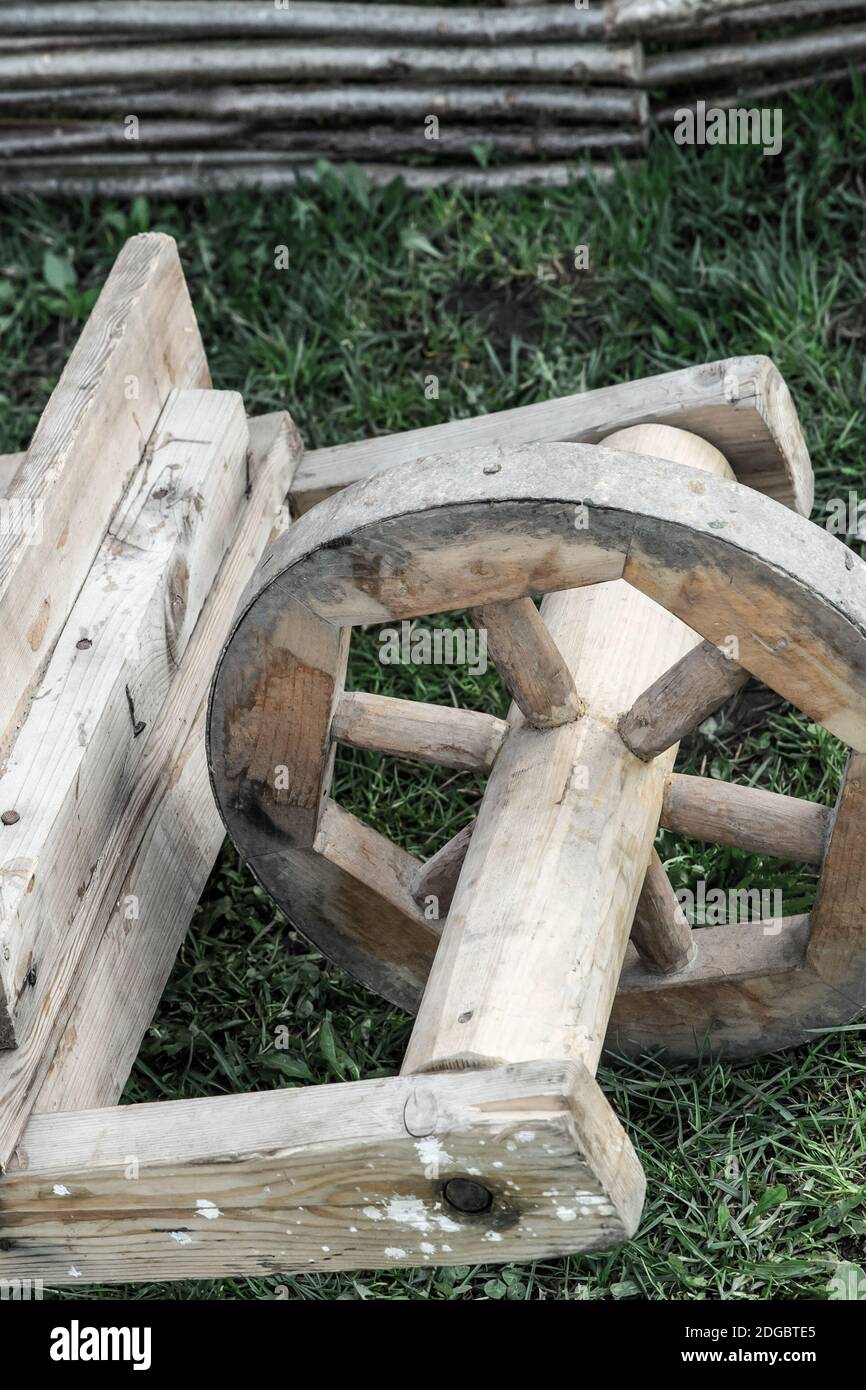 Wooden wheelbarrow old work tool for delivering goods toned background close-up Stock Photo