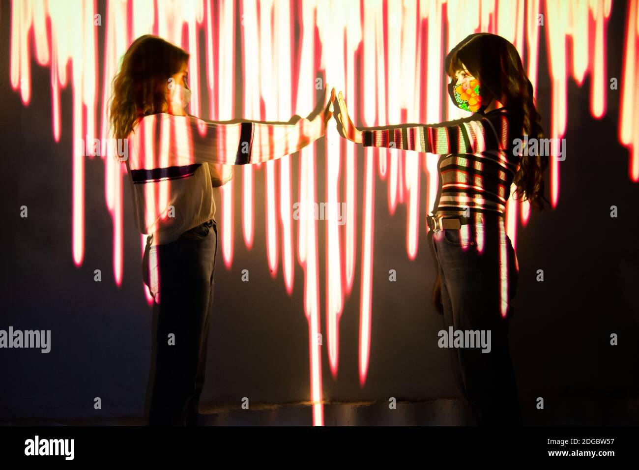 Two women raise their arms to measure safety distance by social