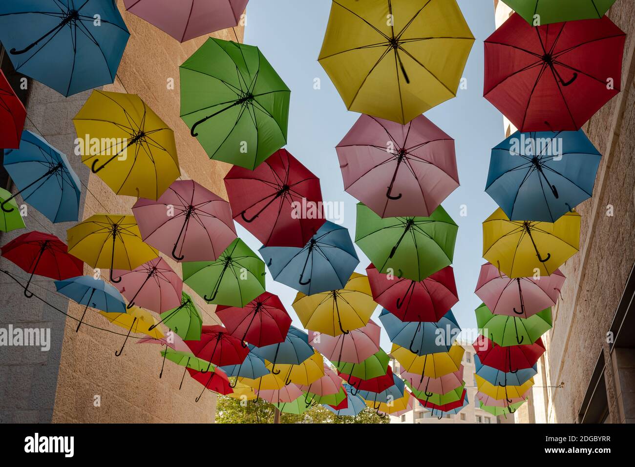 colorful umbrellas hanging on the street along the road Stock Photo
