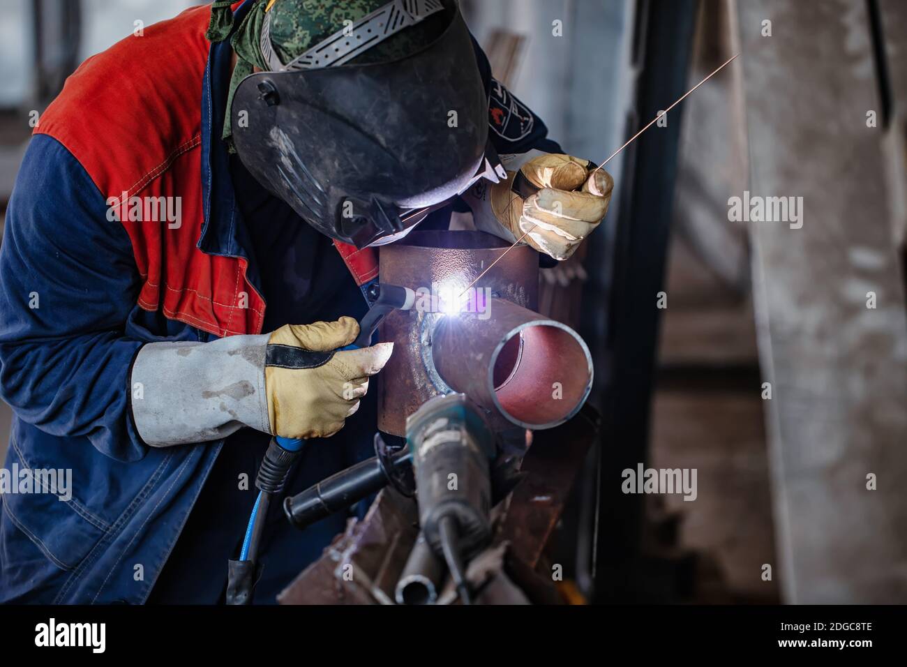 Welder in the shop weld sample from the tube for passing of certification Stock Photo