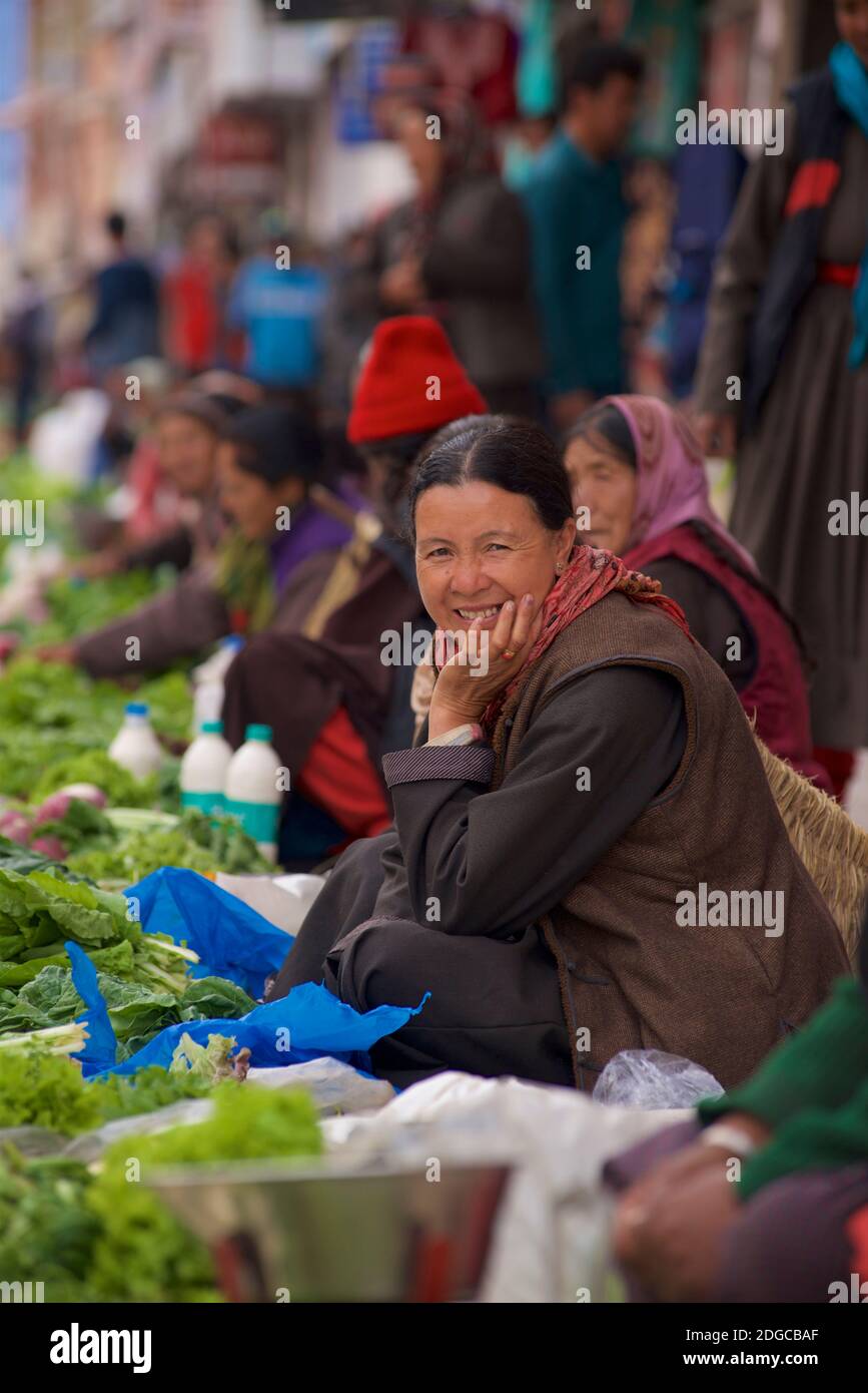 Portrait of a friendly Ladakhi woman in local attire selling vegetables at market, Leh, Jammu and Kashmir, India Stock Photo