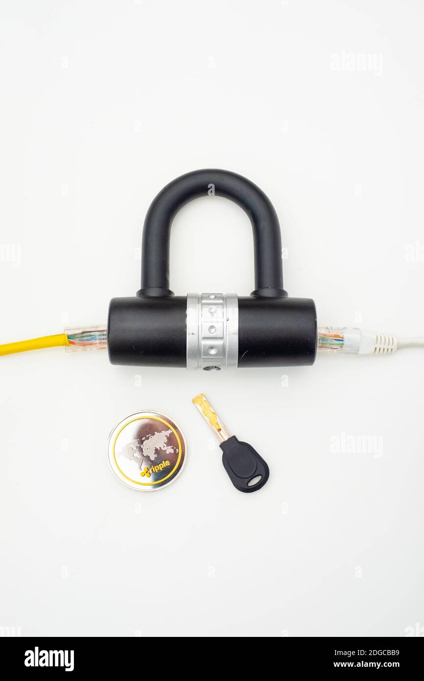 Two computer network cables going through a lock with a key and a crypto currency coin Stock Photo