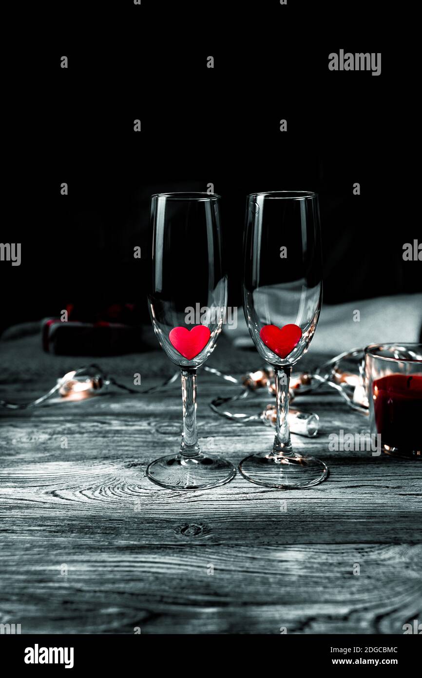 Two glasses with red hearts inside on a black background. Stock Photo