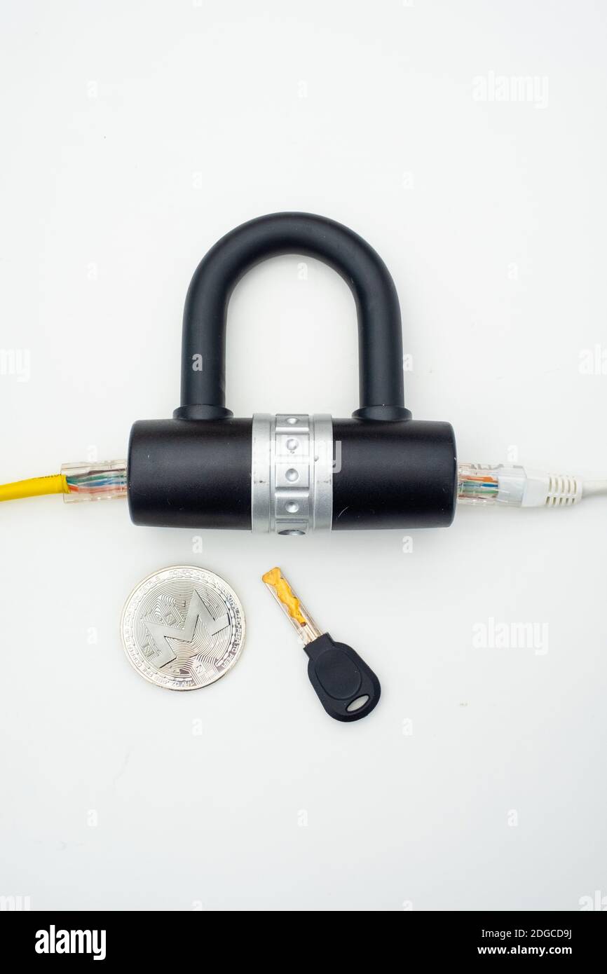 Two computer network cables going through a lock with a key and a crypto currency coin Stock Photo