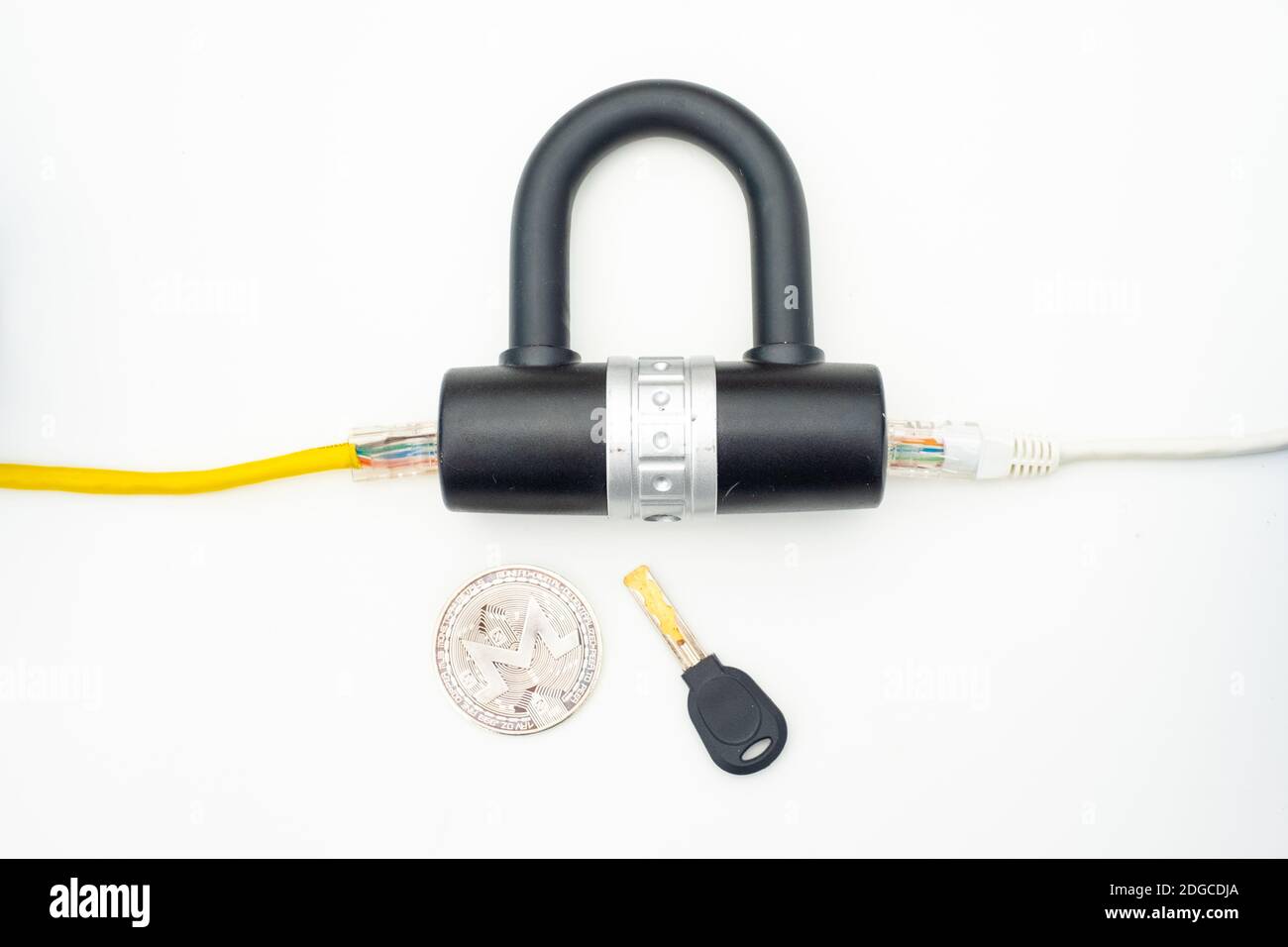 Two computer network cables going through a lock with a key and a crypto currency coin Stock Photo