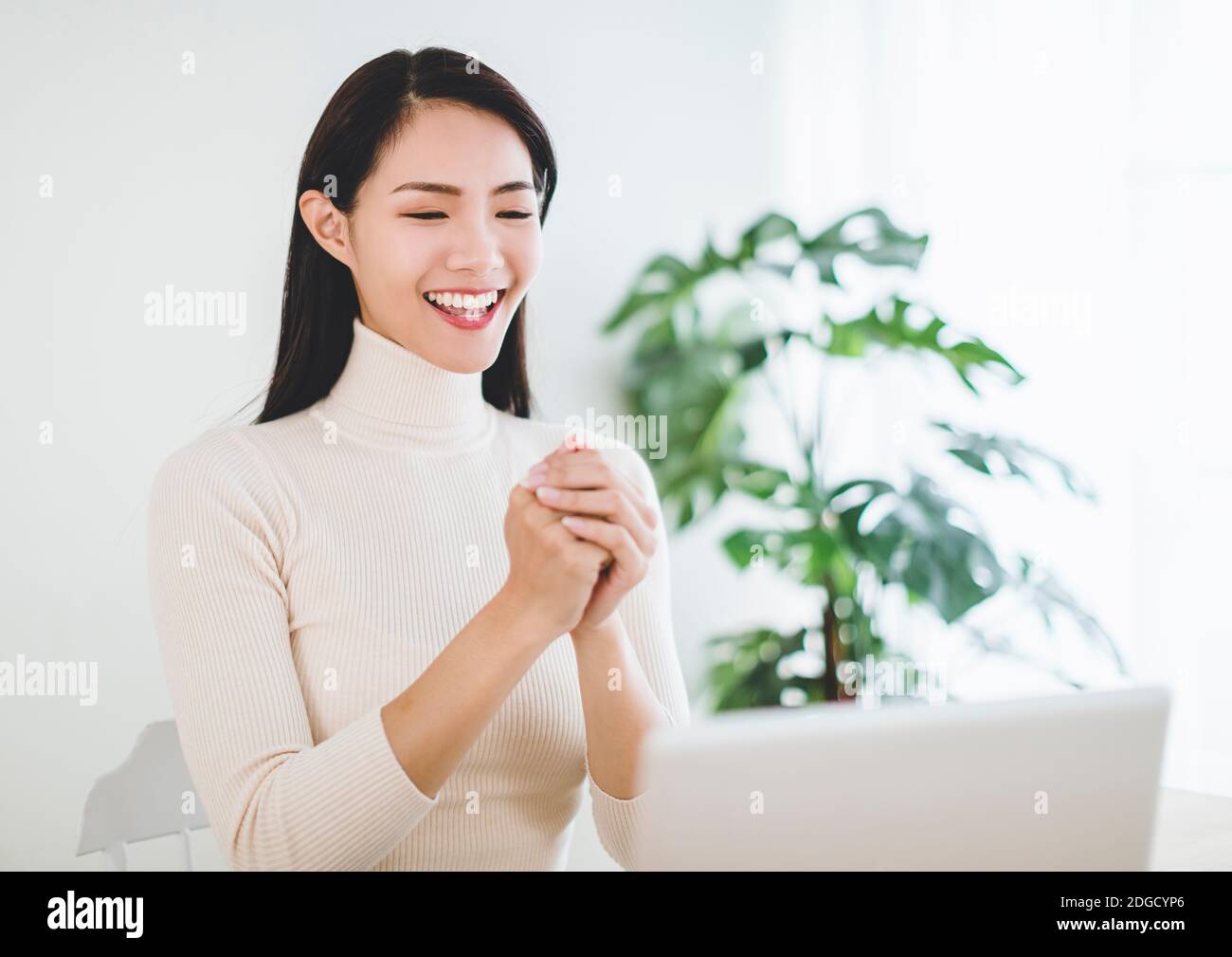 Happy asian young woman  making distance video call with congratulations gesture for chinese new year Stock Photo