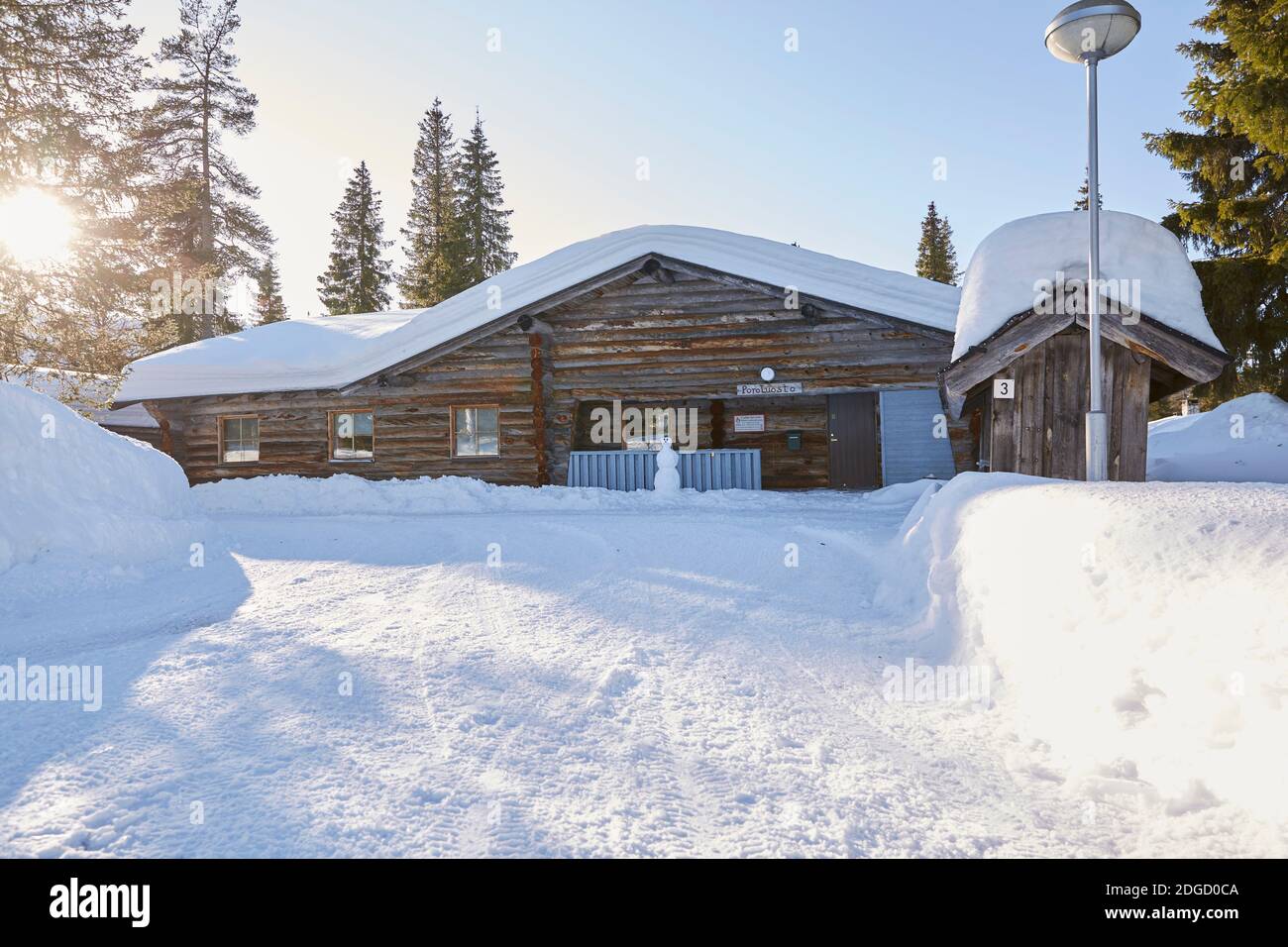 Snowy Log Cabin in the Sun in Lapland Stock Photo
