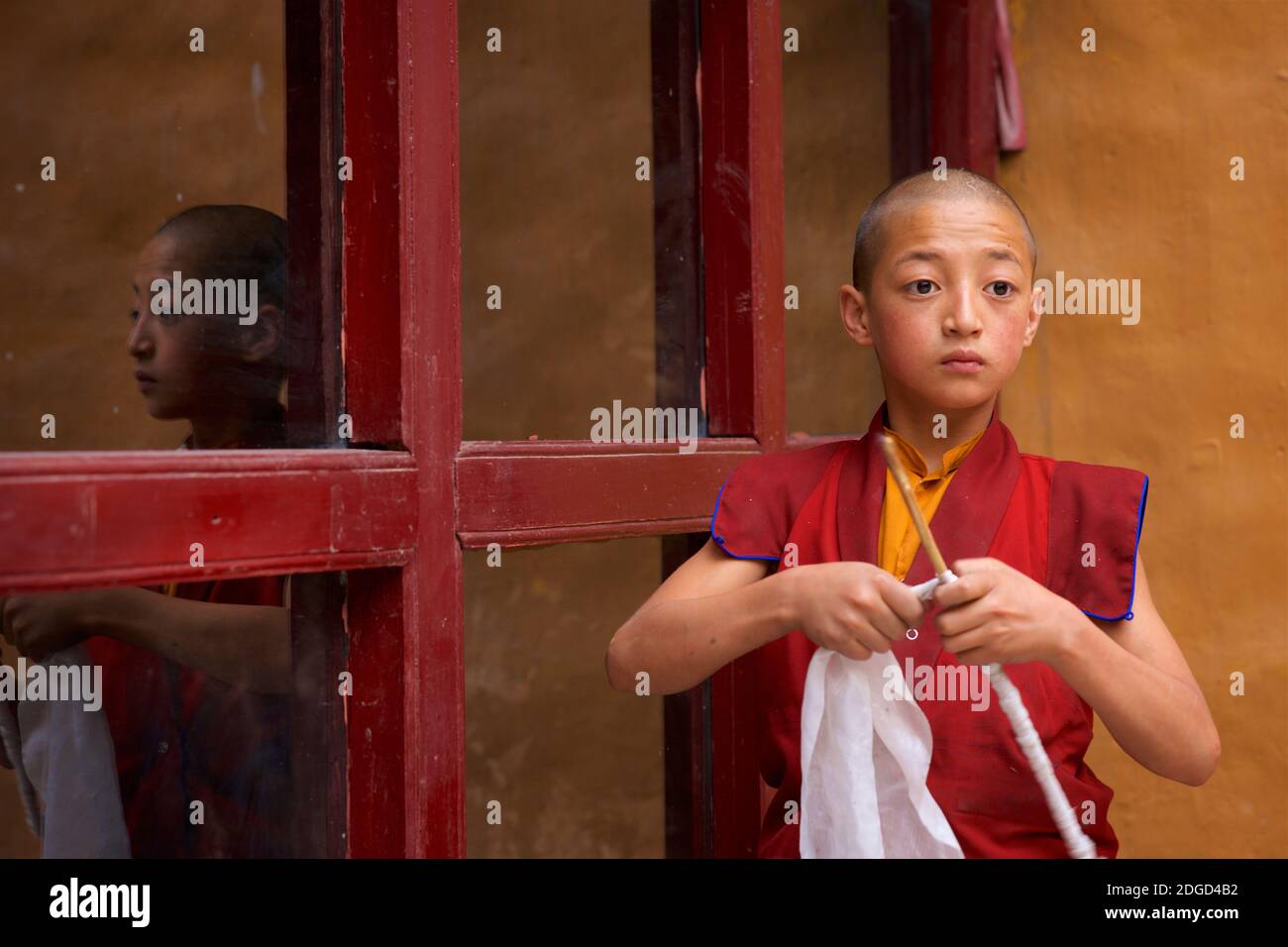 A young, novice monk undertaking chores. Lamayuru monastery, Lamayouro, Ladakh, Jammu and Kashmir, India Stock Photo