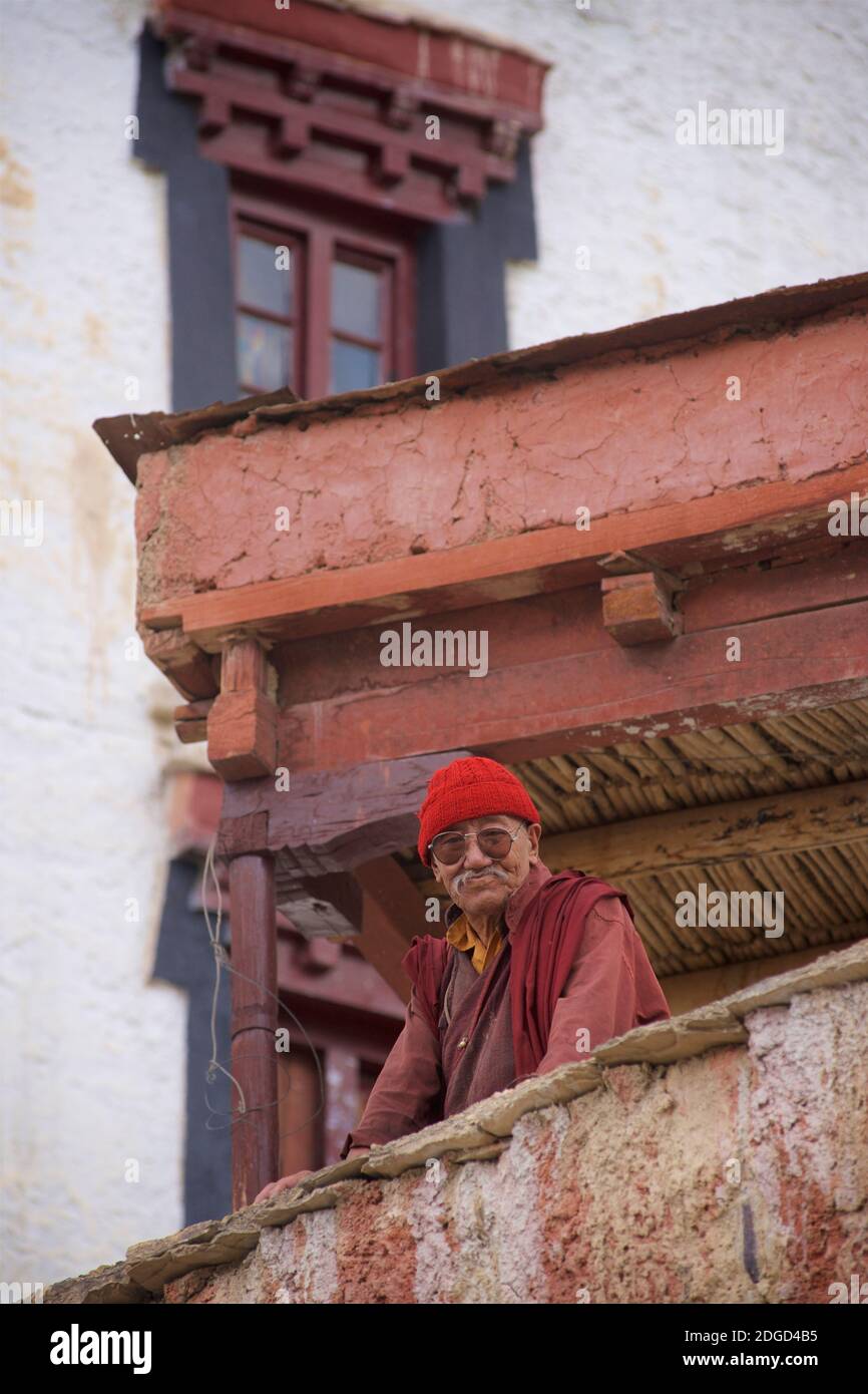 Portrait of an elderly Ladakhi monk in monastic robes, sunglasses and a red cloth hat. Lamayuru monastery, Lamayouro, Ladakh, Jammu and Kashmir, India Stock Photo