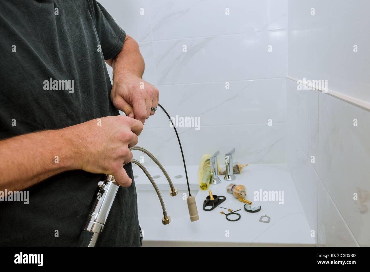 Plumber installing a faucet in a bathroom, only hands to assemble service Stock Photo