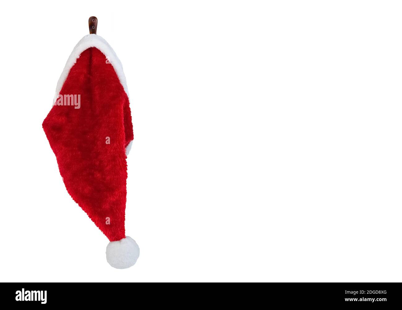 Santa hat cutout isolated hanging on a white wall background with copy