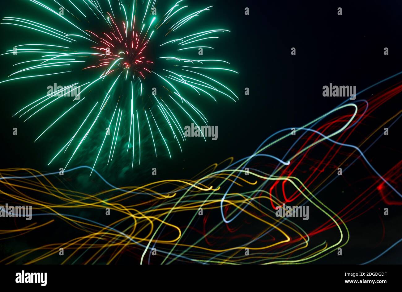 Night fireworks different colors on a laser effect over the rays of