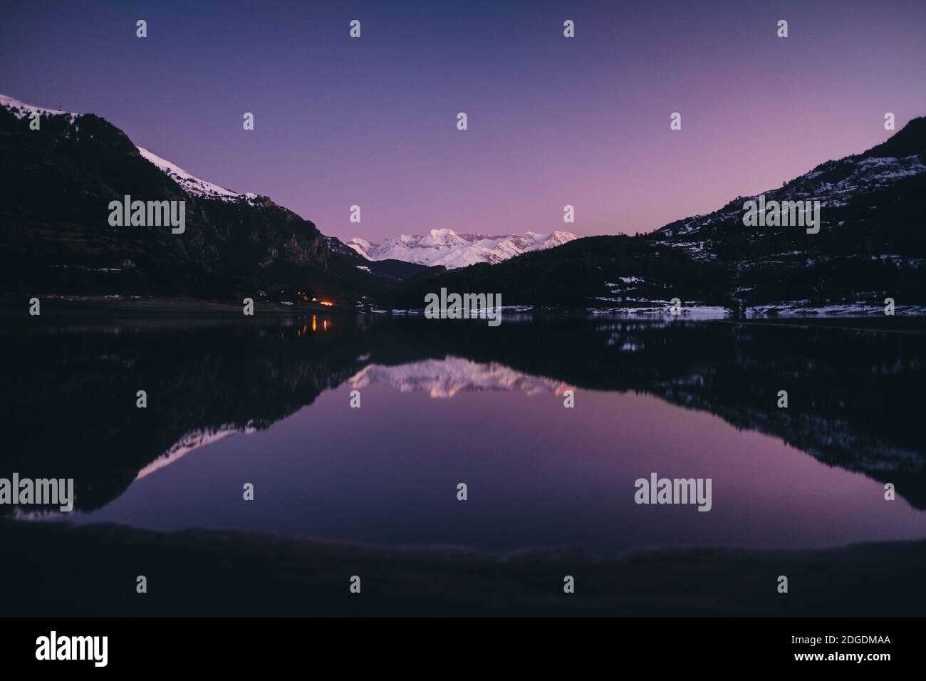Scenic snowcapped mountain reflected on a lake during dusk in the Pyrenees, Sallent de Gallego, Huesca, Spain Stock Photo