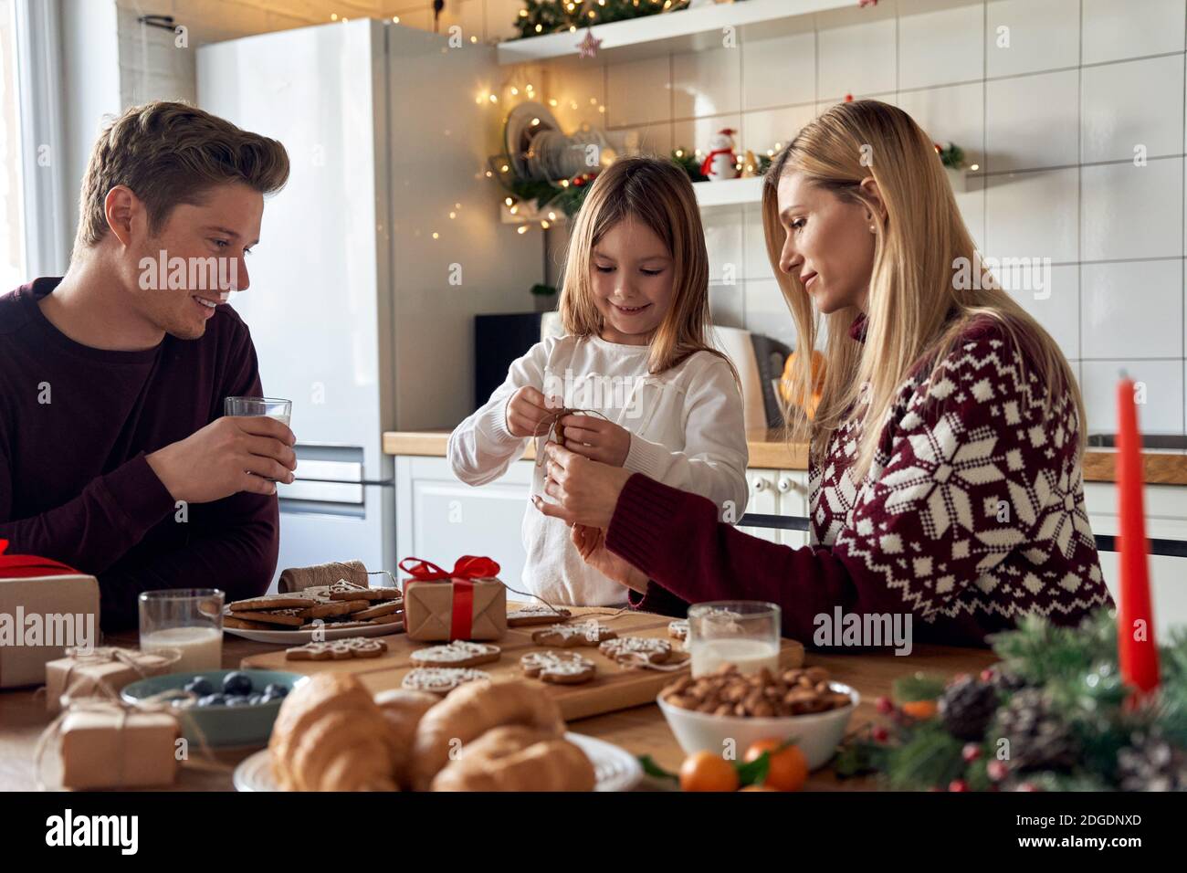 Happy family parents and child making Christmas cookies decorations at home. Stock Photo