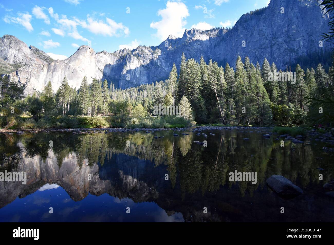 The reflection of granite cliffs and trees in the still calm waters of the Merced River from Valley View in Yosemite National Park, California, USA Stock Photo