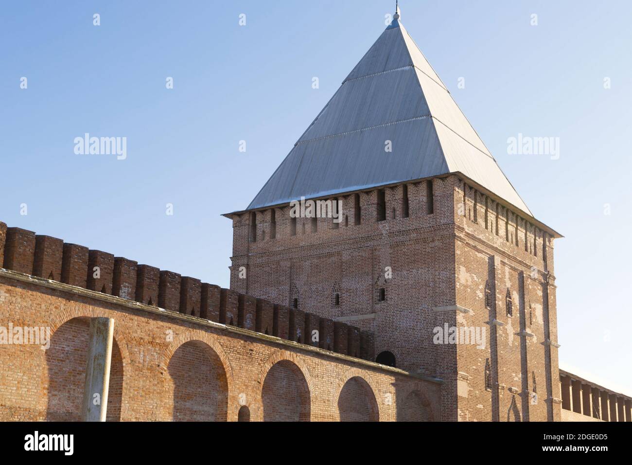 Brick old tower with a pointed roof part of the wall of the Kremlin's protective structures, an old Stock Photo