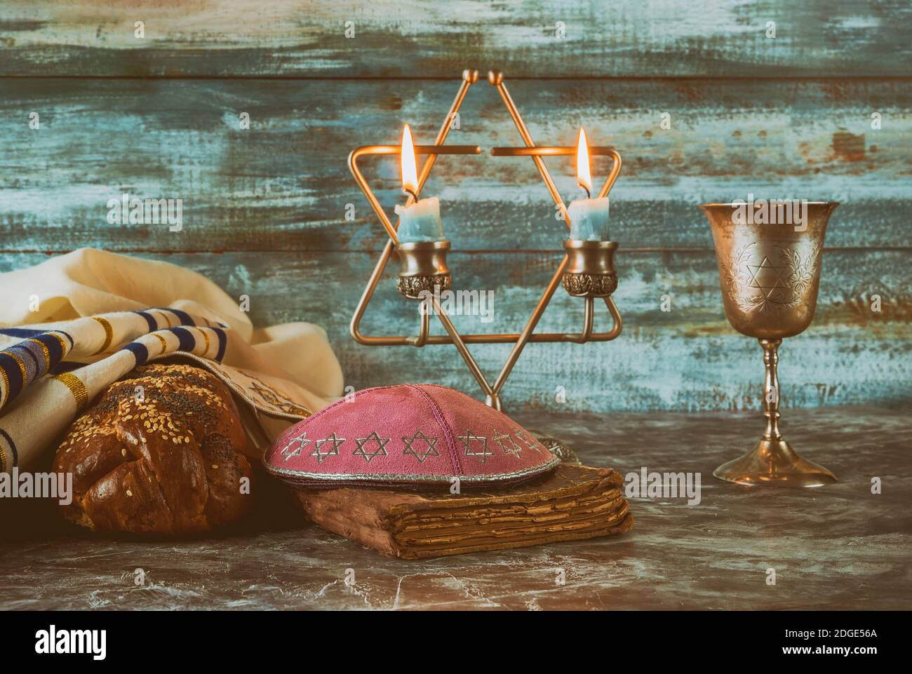 Shabbat eve table candles and cup of wine with covered challah bread, Stock Photo