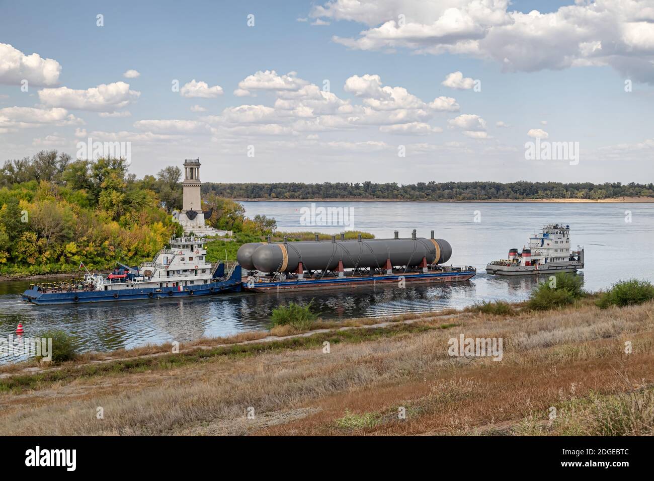 Transportation of large tanks for petrochemical enterprises on river with help of two tugs Stock Photo