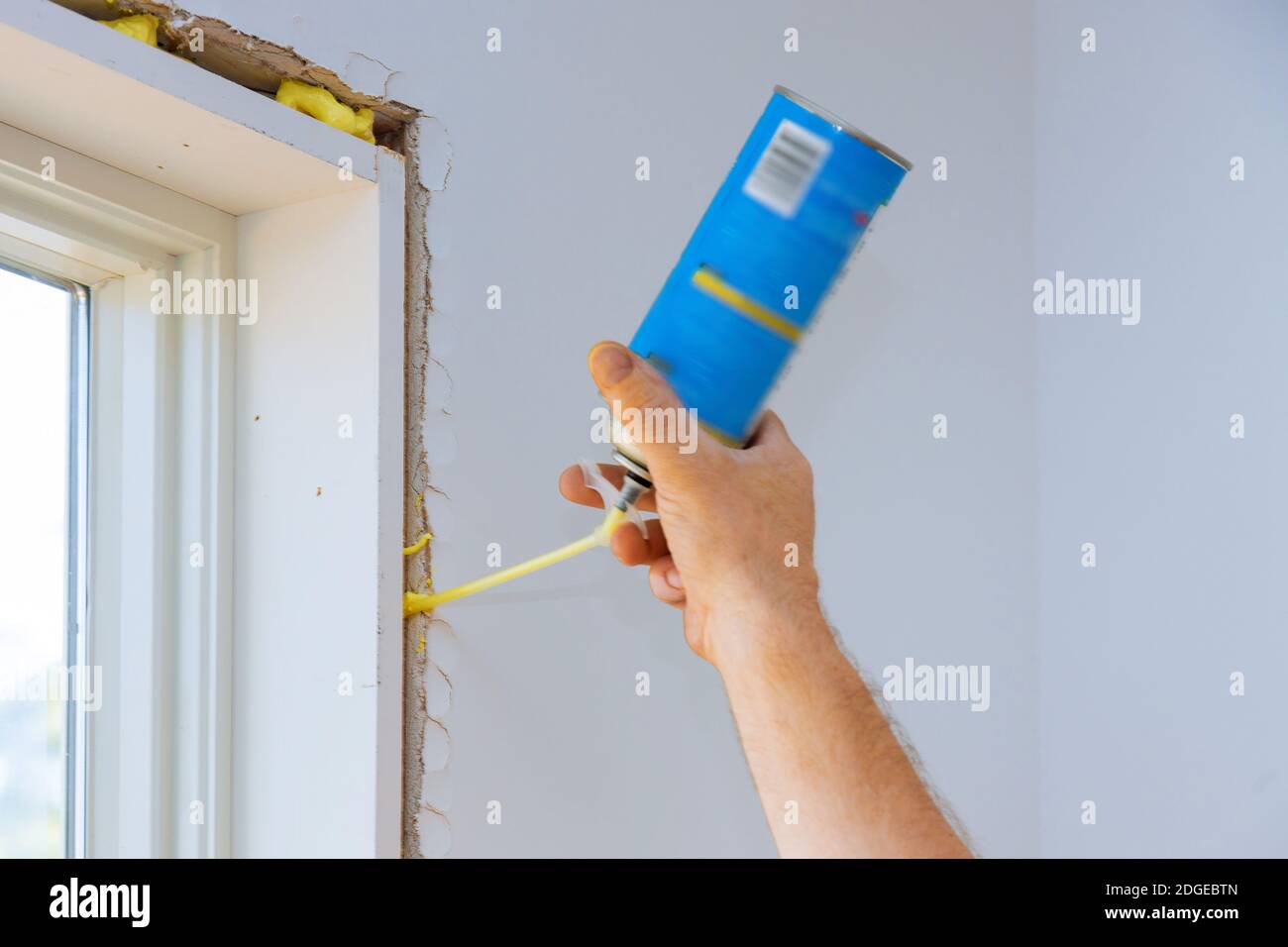 Hand holding polyurethane expanding foam glue gun applicator with