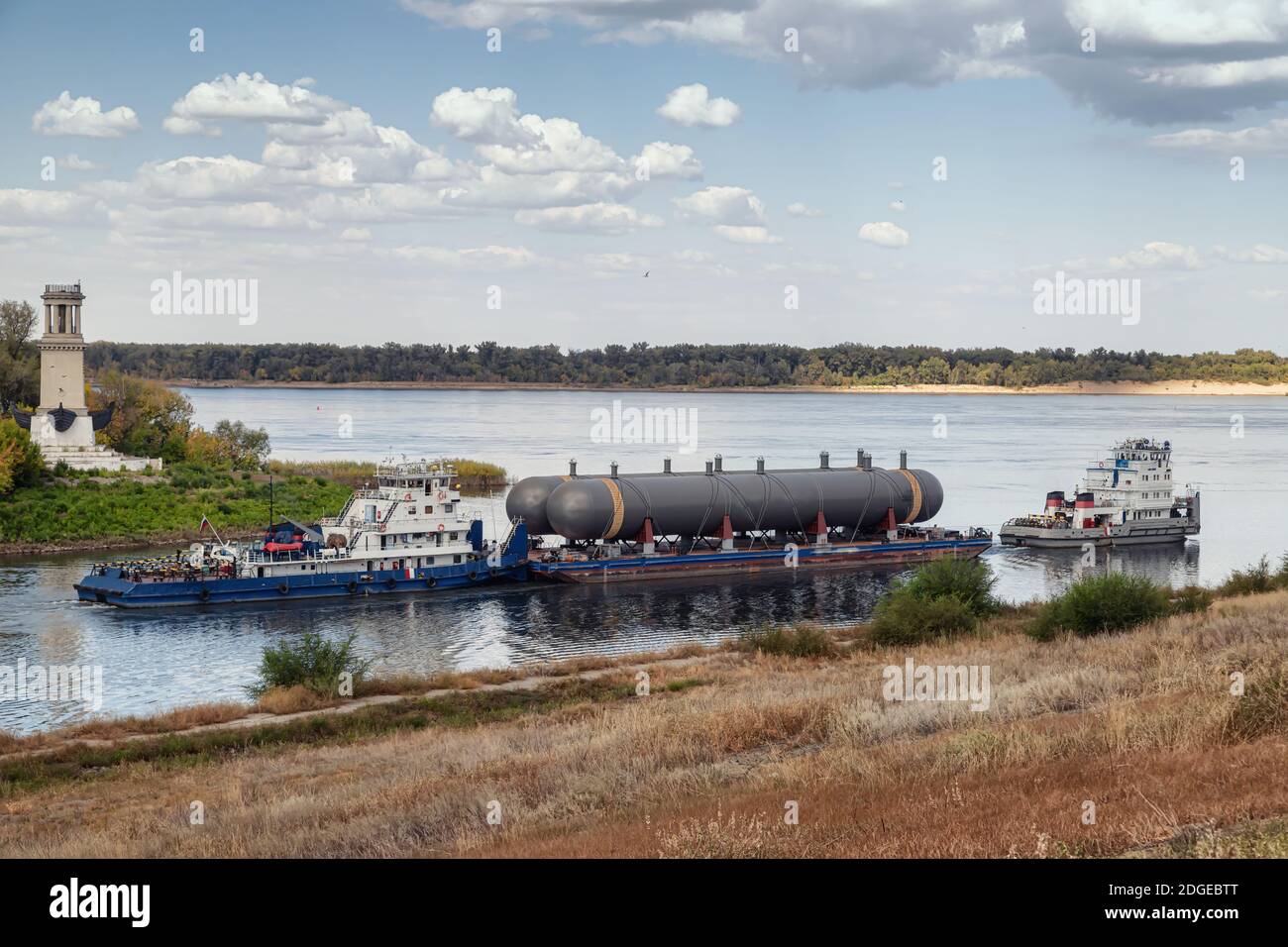 Transportation of large tanks for petrochemical enterprises on river with help of two tugs Stock Photo