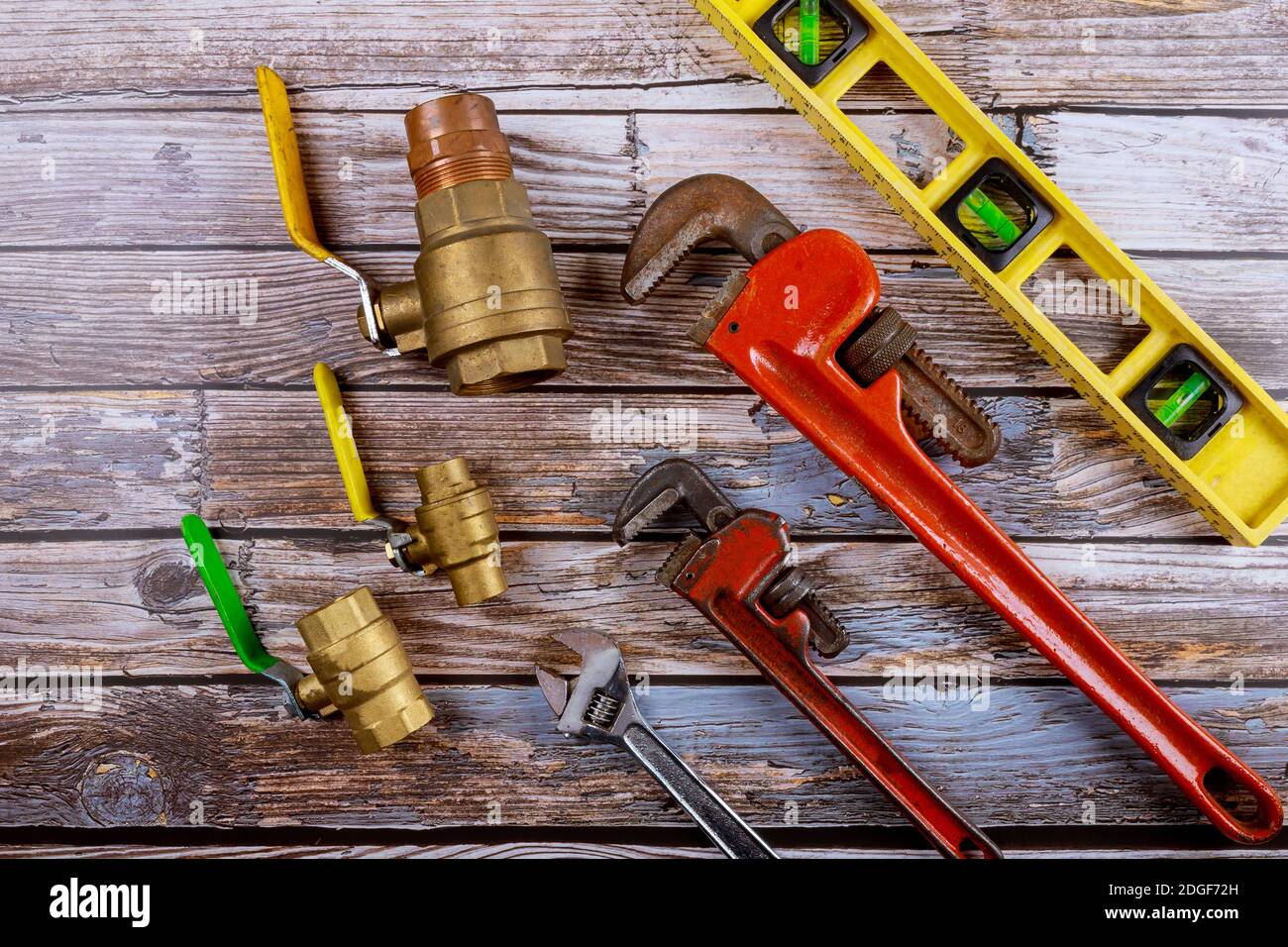 Monkey wrench brass plumbing fittings and level tape on construction concept. Stock Photo
