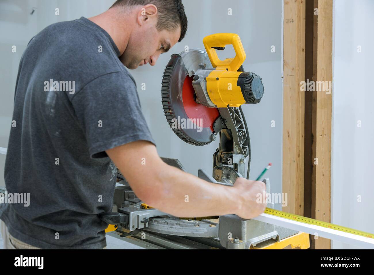 Construction worker remodeling home Carpenter cutting wooden trim board