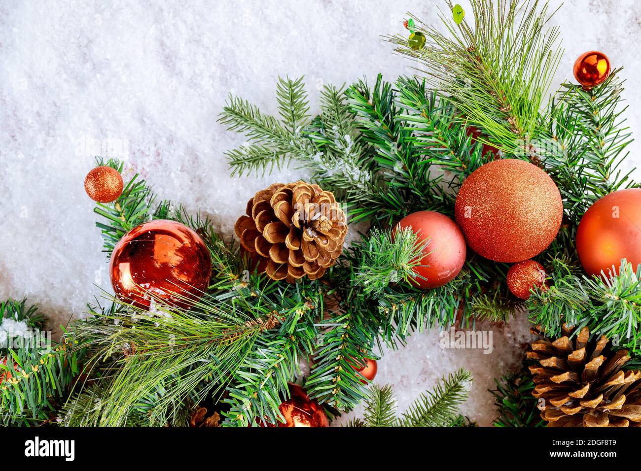 Christmas snow decorations background on fir branch with pine cone ...
