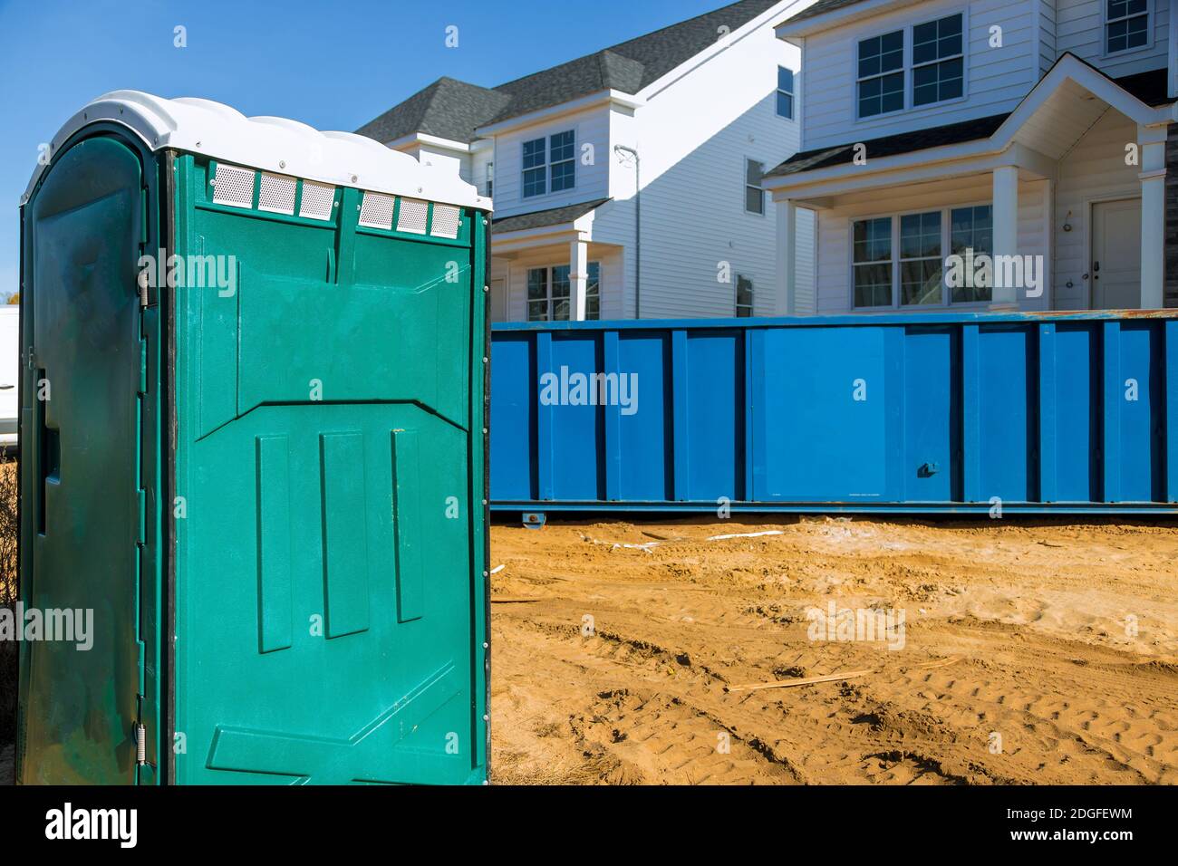 Portable bio toilet cabins at the construction removal of debris construction waste building demolition with rock and concrete r Stock Photo