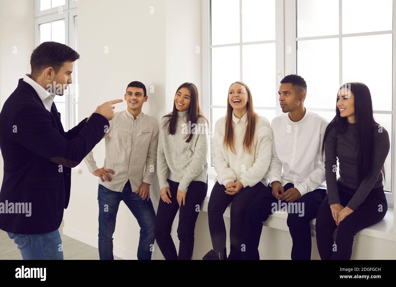 Office workers listen to their colleague who tells an interesting story during a break at work. Stock Photo