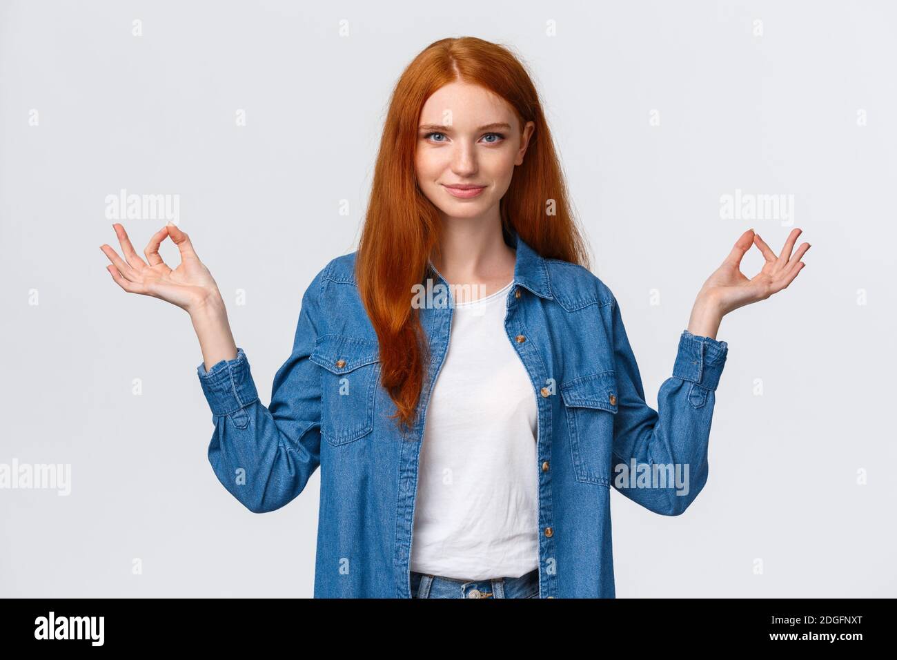 Waist-up portrait confident and relieved, patient good-looking redhead woman calm down daily yoga practice with app, hold hands Stock Photo