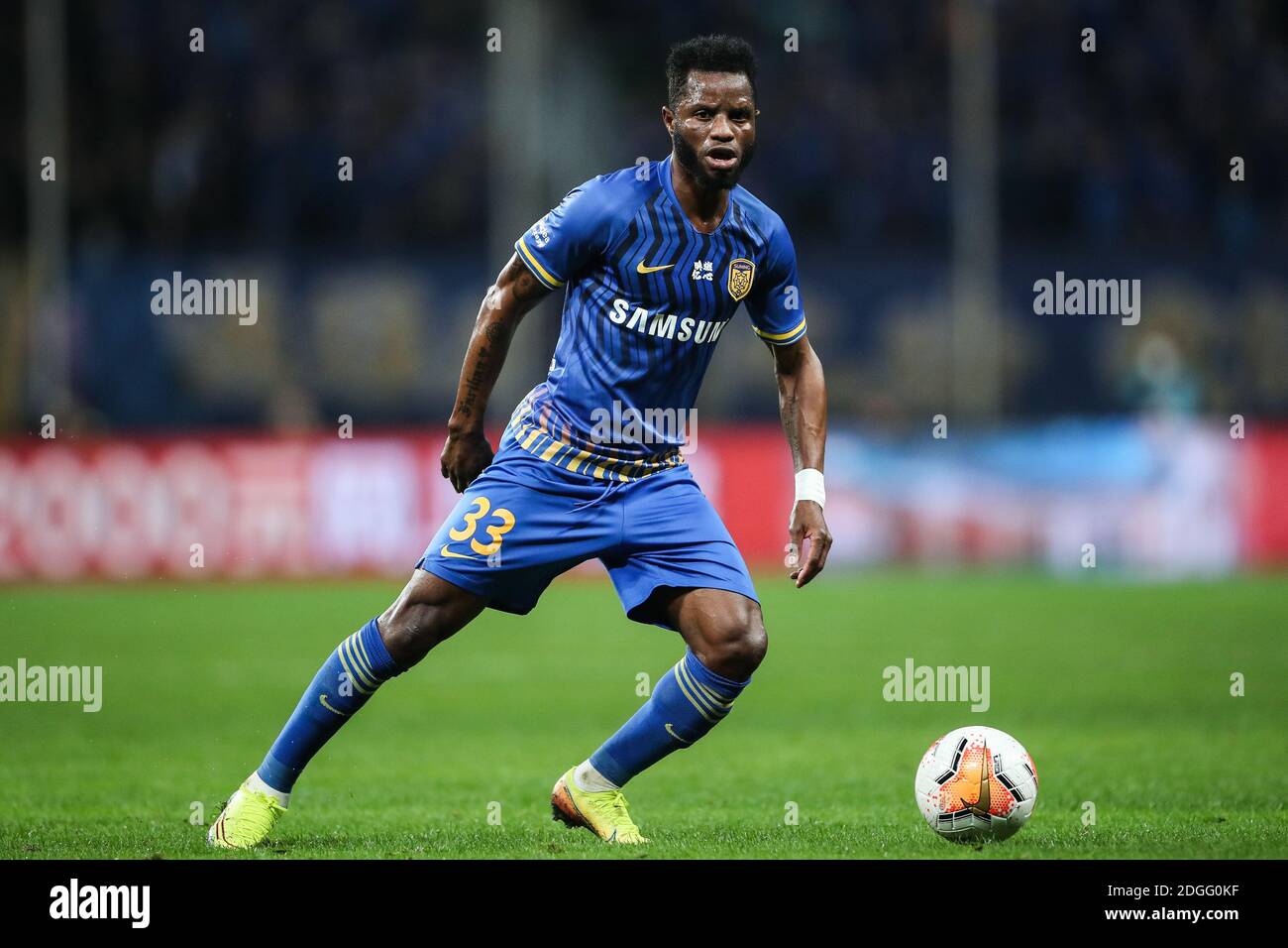 Ghanaian football player Mubarak Wakaso of Jiangsu Suning F.C., rihgt, keeps the ball during the second round of the final of 2020 Chinese Super Leagu Stock Photo