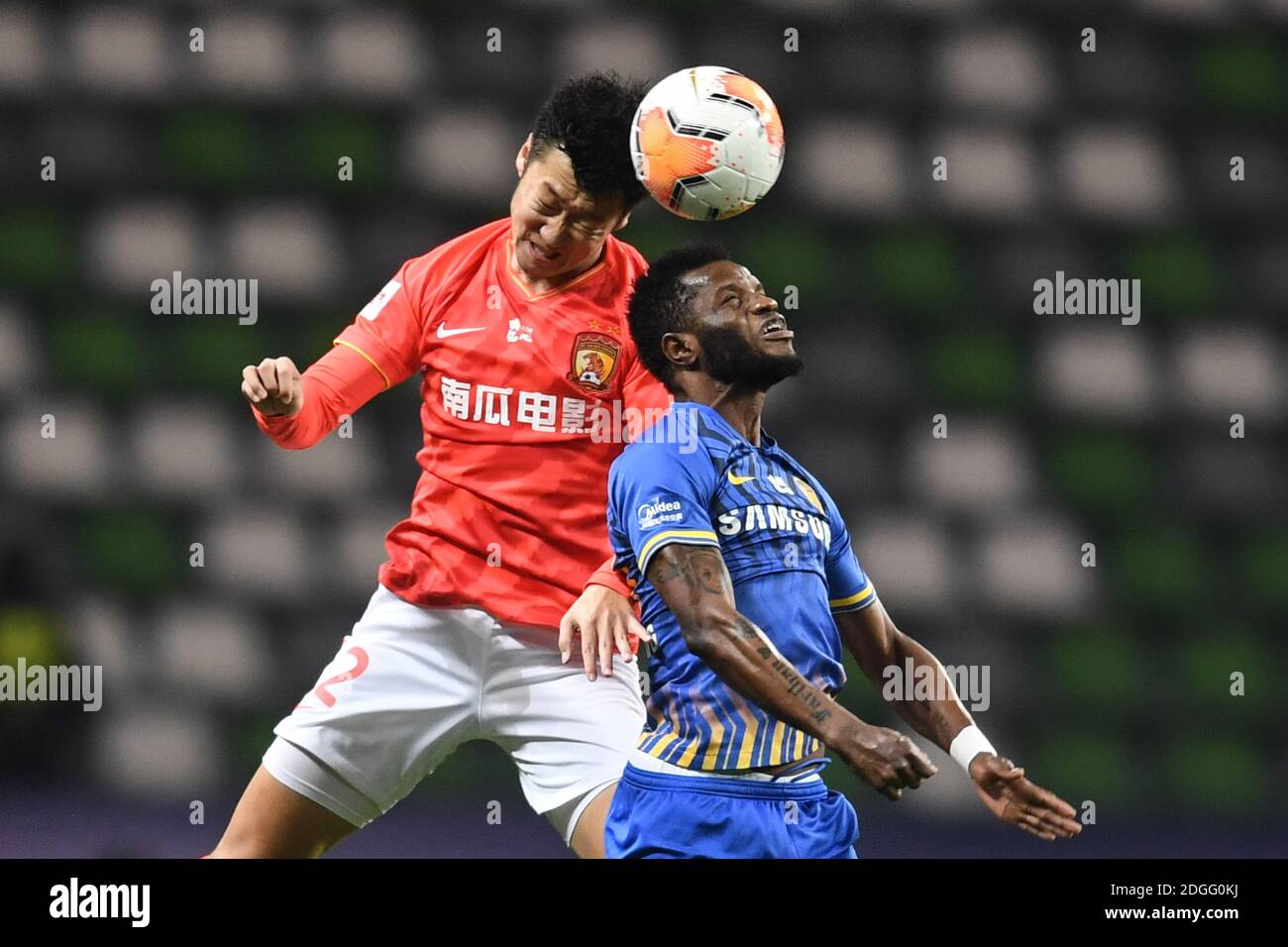 Ghanaian football player Mubarak Wakaso of Jiangsu Suning F.C., rihgt, jumps for a head ball during the second round of the final of 2020 Chinese Supe Stock Photo
