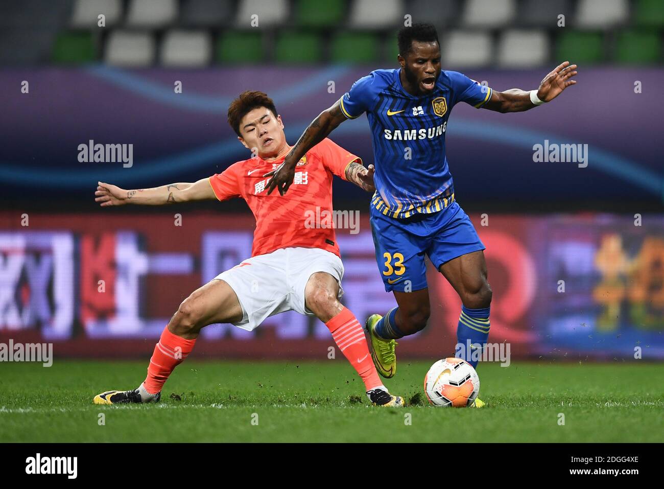 Ghanaian football player Mubarak Wakaso of Jiangsu Suning F.C., rihgt, protects the ball during the second round of the final of 2020 Chinese Super Le Stock Photo