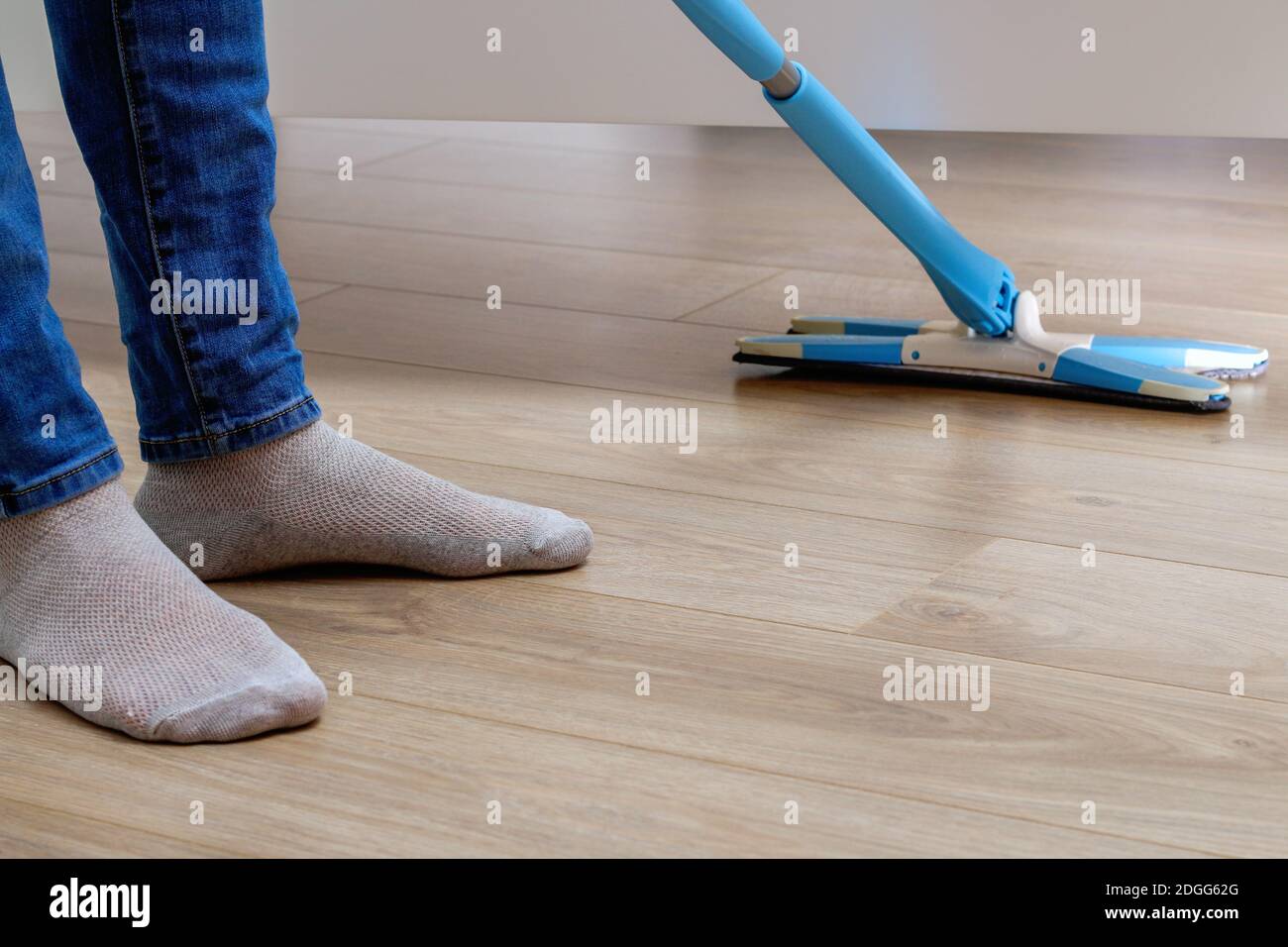 A man washes the floors with a mop in the room. Under the bed. Cleaning