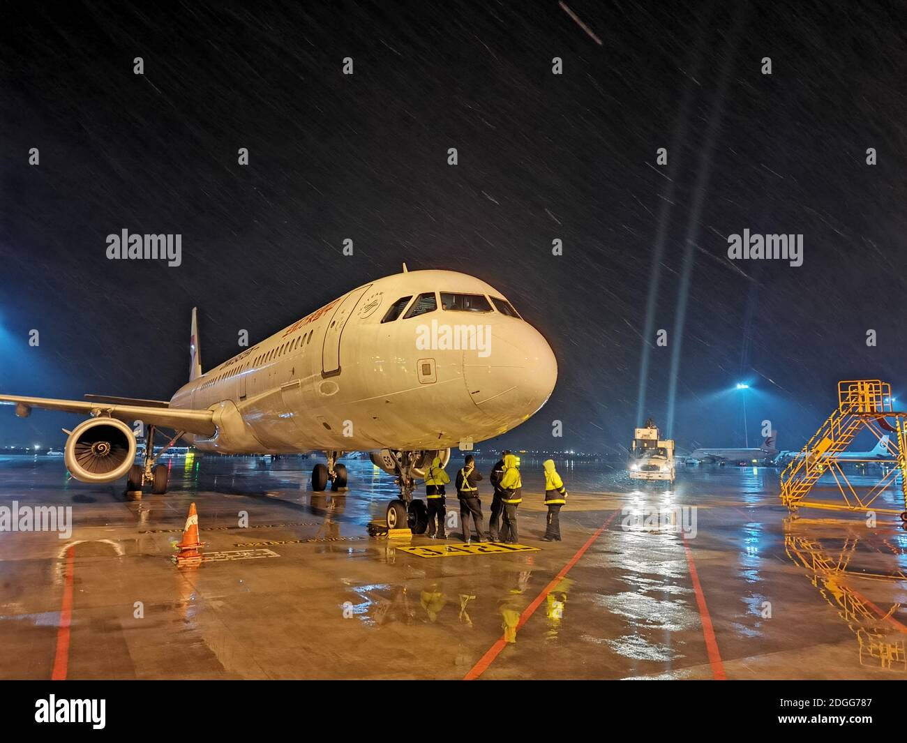 An airplane is deiced while snow on runways are removed to ensure planes taking off smoothly and