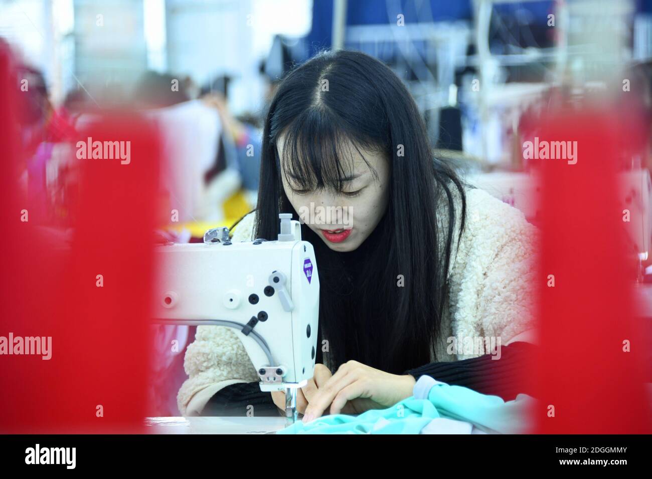 Workers make clothes at an apparel manufacturing company in Enshi city