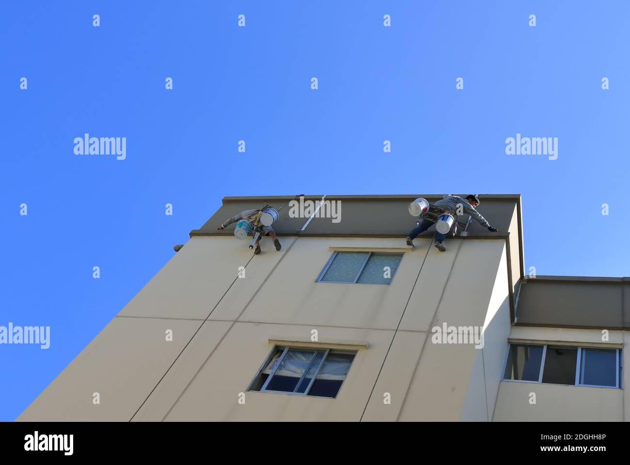 Bangkok, Thailand- December 9, 2020: Workers are repairing cracked wall outside a tall building by using sealant silicone and then painting Stock Photo