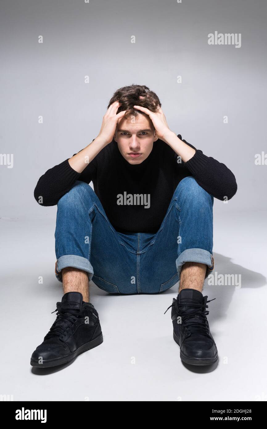 Premium Photo | A guy of model appearance in black clothes poses on a gray  studio background