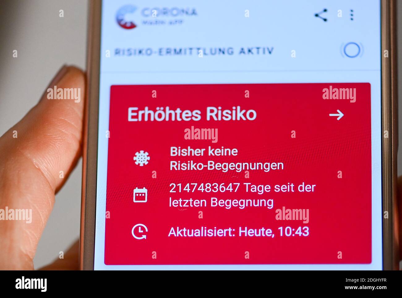 06 December 2020, Berlin: On a smartphone, the open Corona warning app with red display indicates an increased risk despite no risk encounter. In addition, an unreasonable number of days since the last encounter are displayed. The data is obviously displayed incorrectly. The Corona-Warn-App works with several parameters to determine the risk, the most important of which is the duration of contact with a person who is later tested corona-positive and the distance to this person. Encounters lasting less than ten minutes are generally considered harmless, as are those in which both persons were a Stock Photo