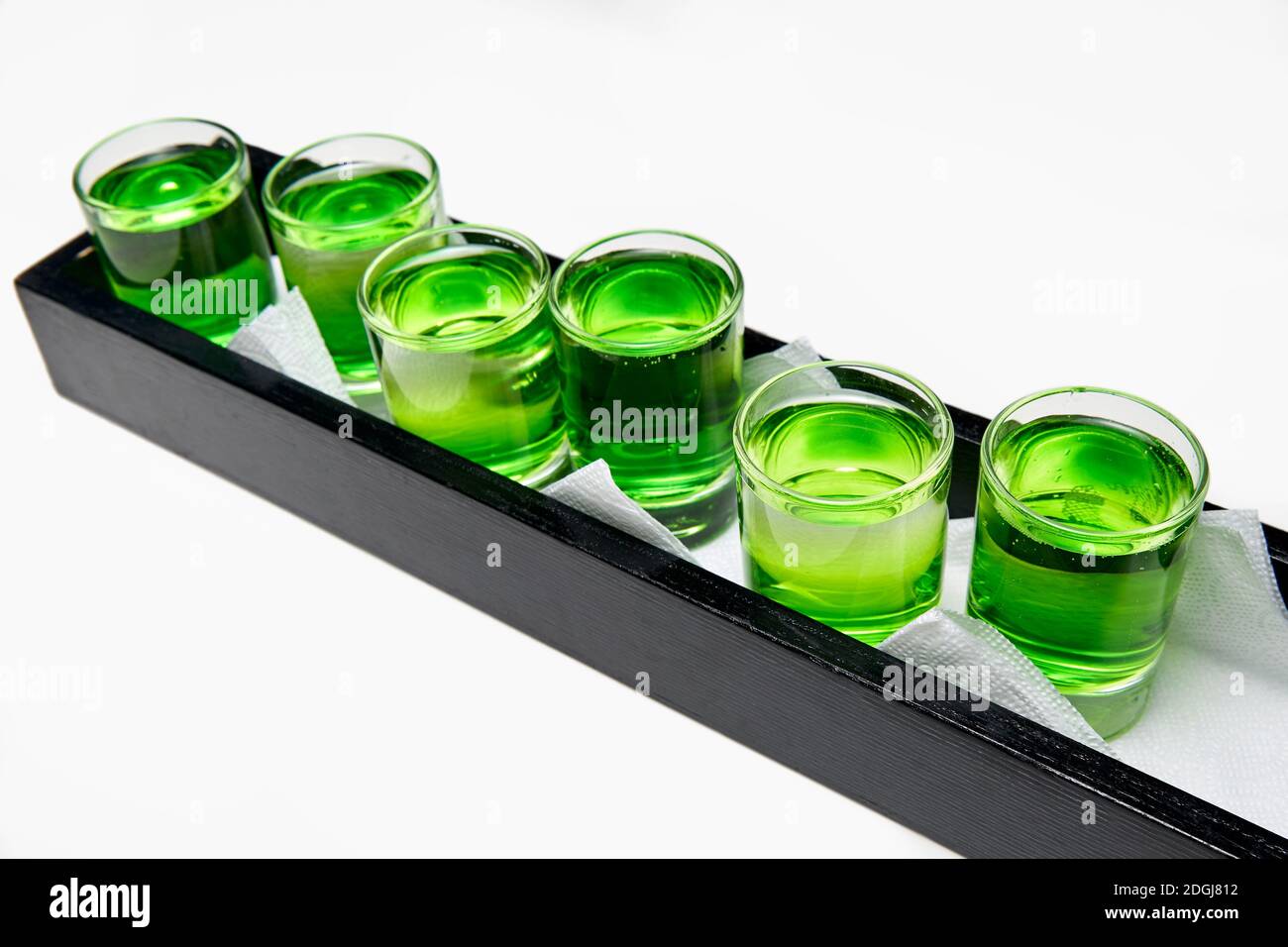 Several whitegreen alcoholic drinks shots on the bar counter Stock