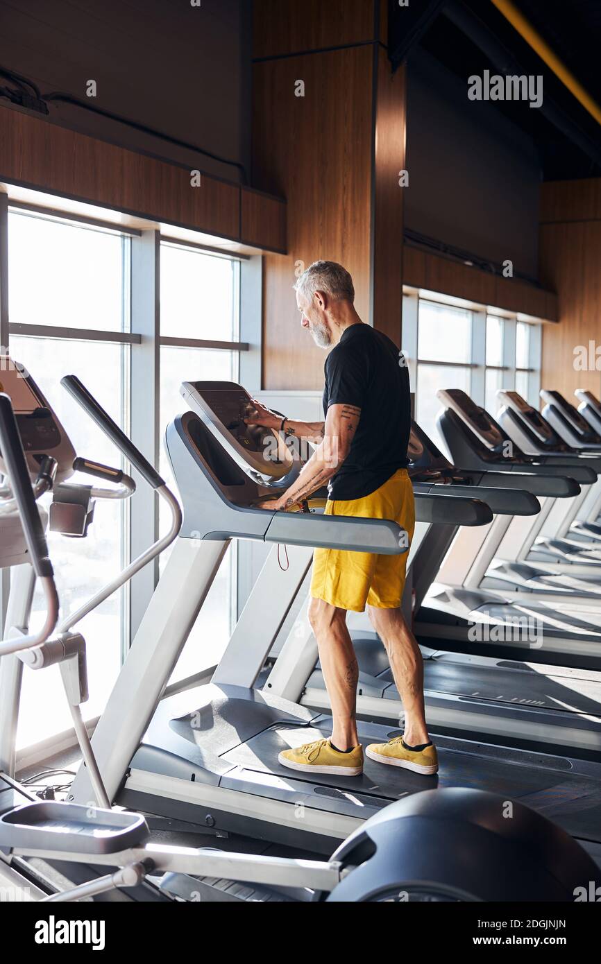 Man setting the control panel on the treadmill Stock Photo