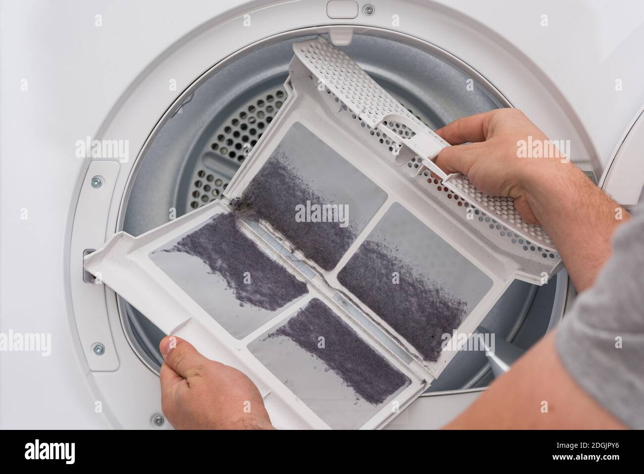 Man shows dust and dirt trapped by the after use clothes dryer filter Stock  Photo - Alamy