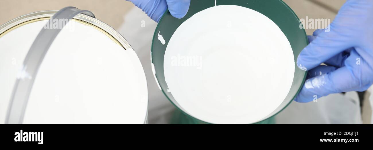 White paint in can and in building tank closeup Stock Photo Alamy