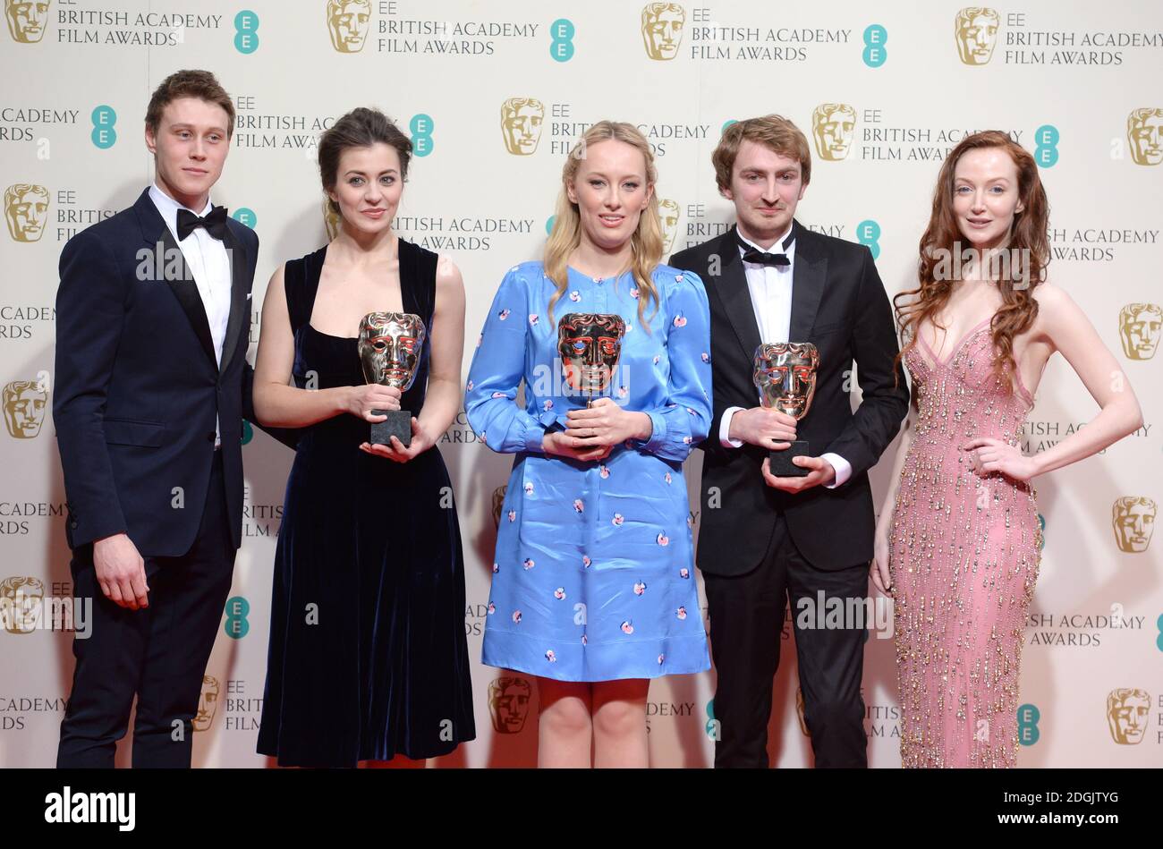 George MacKay and Olivia Grant in the Press Room at the EE British Academy Film Awards 2015, with the Best Animated Short Winners Jennifer Majka, Daisy Jacobs and Chris Hees (The Bigger Picture) held at the Royal Opera House in Covent Garden, London UK. Stock Photo