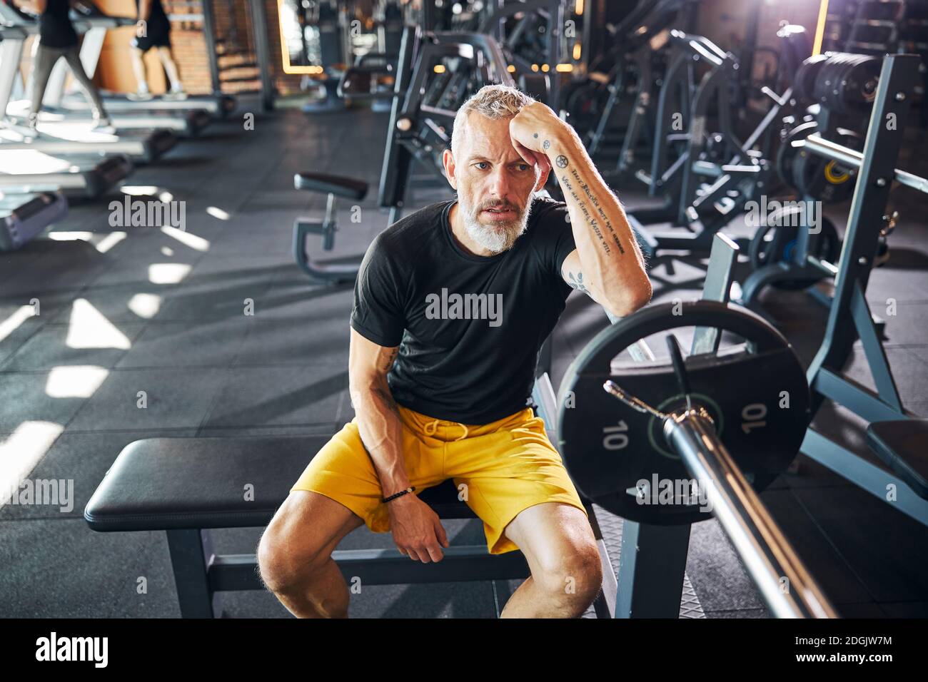 Sportsman with a vacant look sitting on the bench Stock Photo