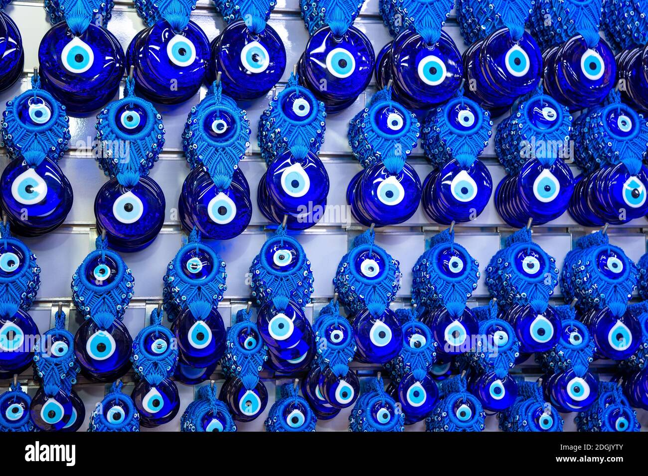 Various blue amulets evil eye beads nazar boncugu Hanging on the white colored wall background in antalya turkey Stock Photo
